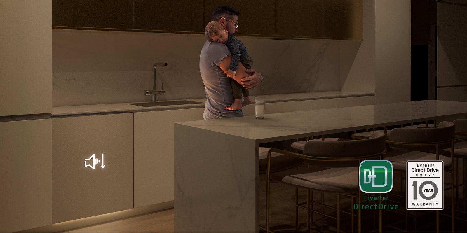 Mann som holder sovende baby i et svakt opplyst kjøkken, innebygd oppvaskmaskin som opererer stille i bakgrunnen.