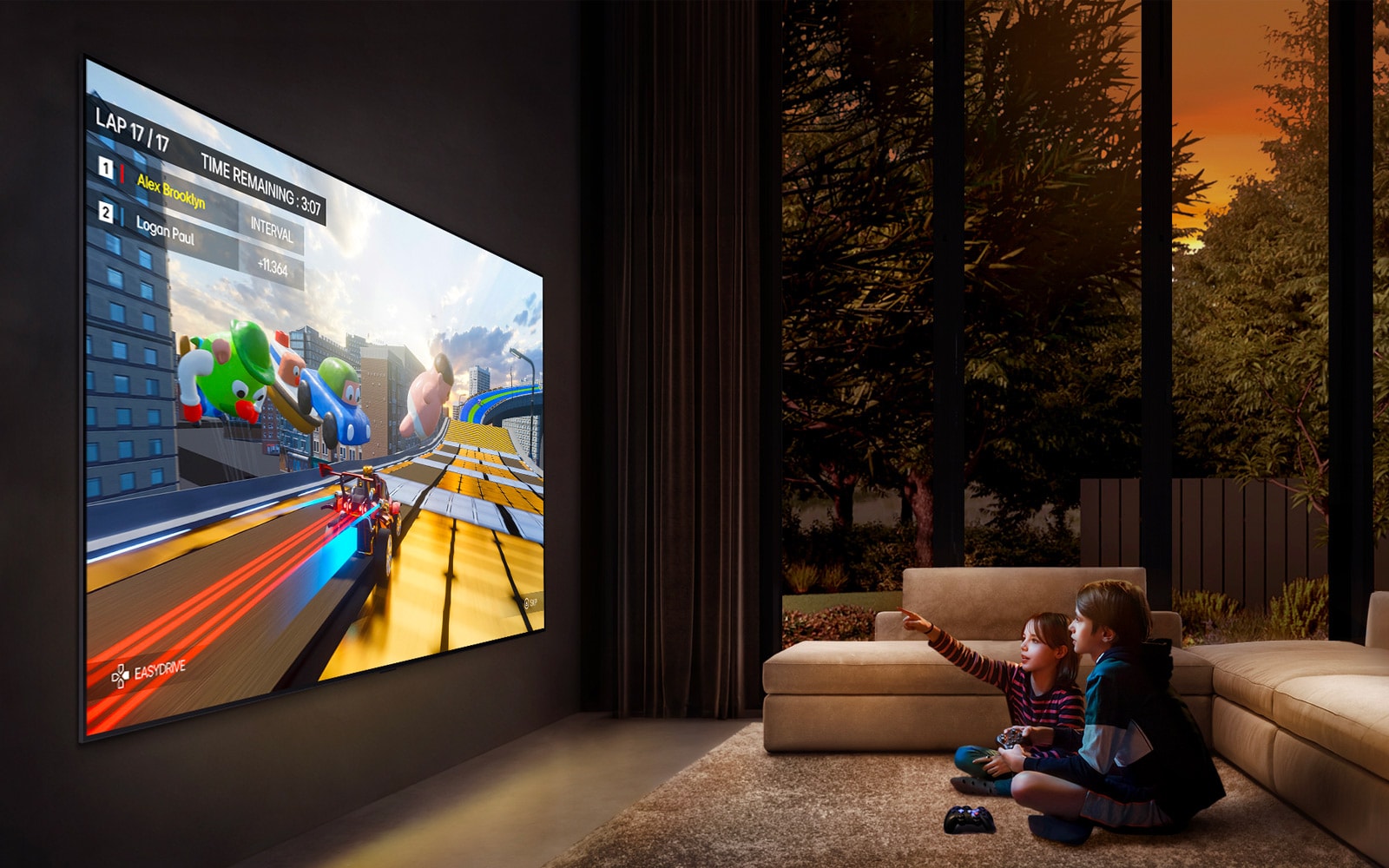 En sidevinkelvisning av en ultrastor LG-TV montert på en vegg i en koselig stue som viser et fargerikt spill, og to barn som sitter på gulvet foran TV-en som holder spillkontrollere.