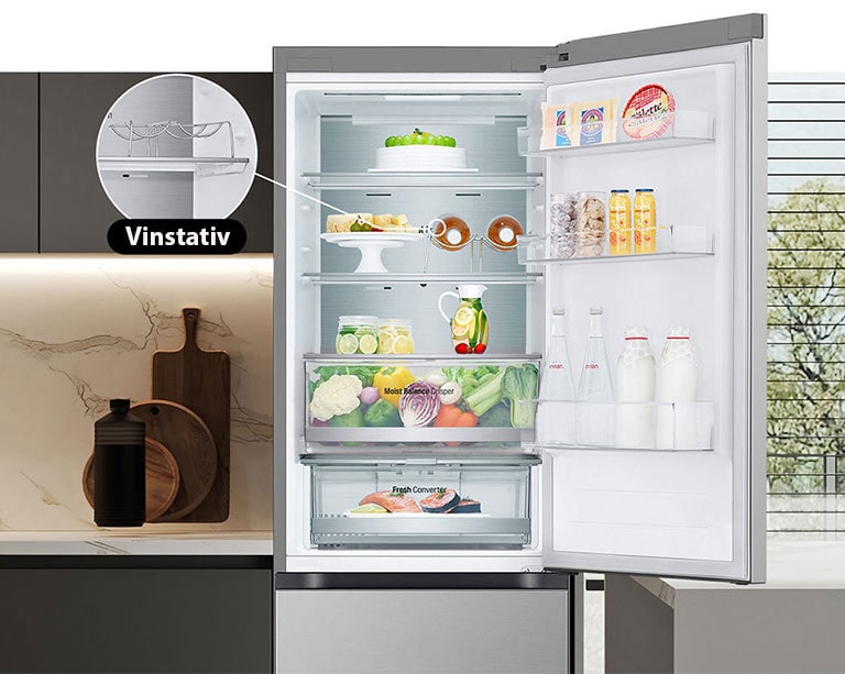 Kjøleskap fylt med fersk mat, med åpen dør som viser vinstativ og foldehyller.