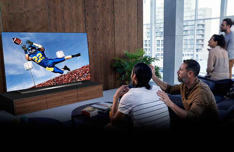 Folk ser på Tottenham-kampen på TV-en i stua