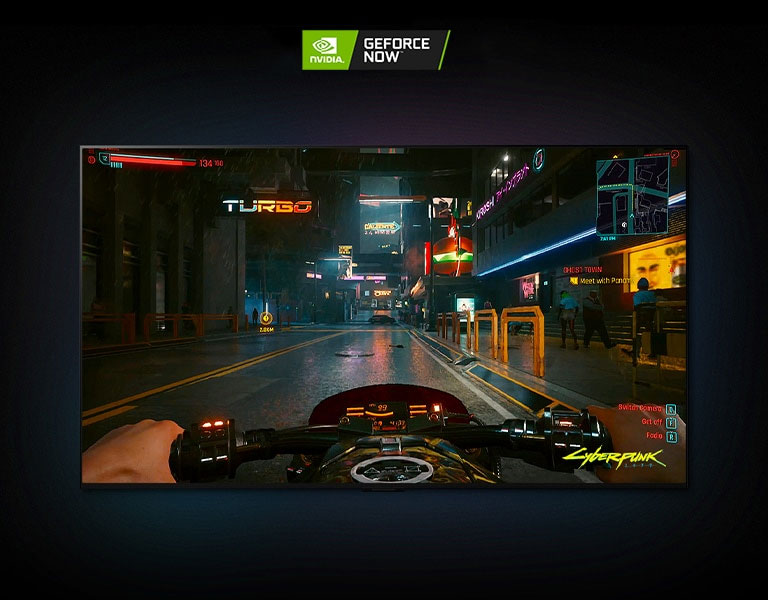 I en scene fra Cyberpunk 2077 som vises på en LG OLED-skjerm, kjører spilleren på en motorsykkel langs en neonbelyst gate.