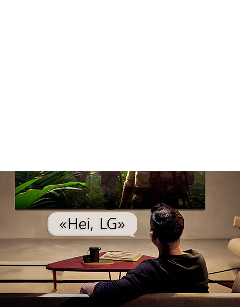 LG OLED AI B6E med Far Field Voice Recognition aktiveres gjennom en talekommando når en person som sitter i rommet sier «Hei, LG» mot TV-en, noe som indikerer håndfri taleinteraksjon i TV-grensesnittet.