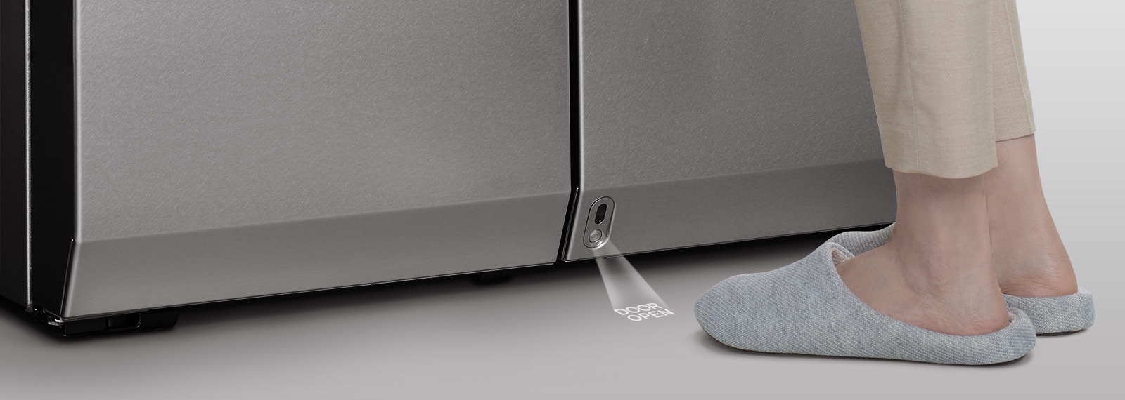 Føttene er lagt rett foran sensoren til den automatiske døråpneren til LG SIGNATURE-kjøleskapet.