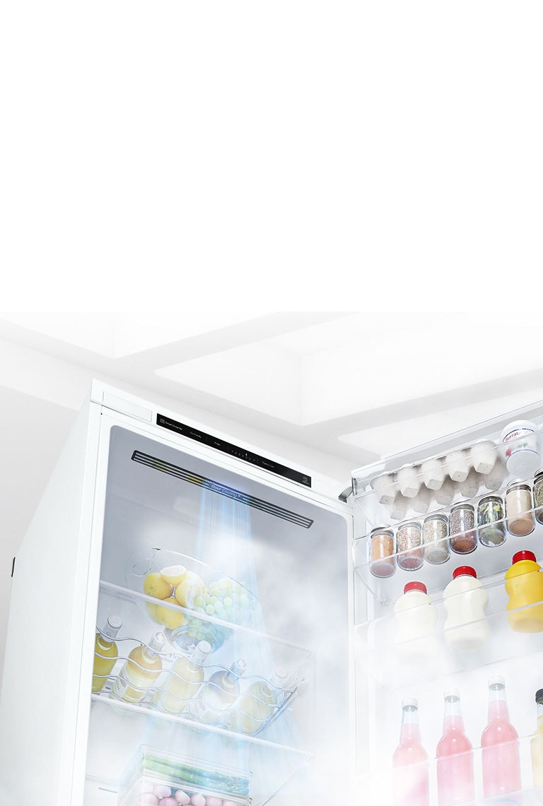 Et åpent kjøleskap fylt med varer vises fra en vinkel. Hvit luft blåser fra toppen av innsiden og ned omkring all maten for å holde den kjølig.