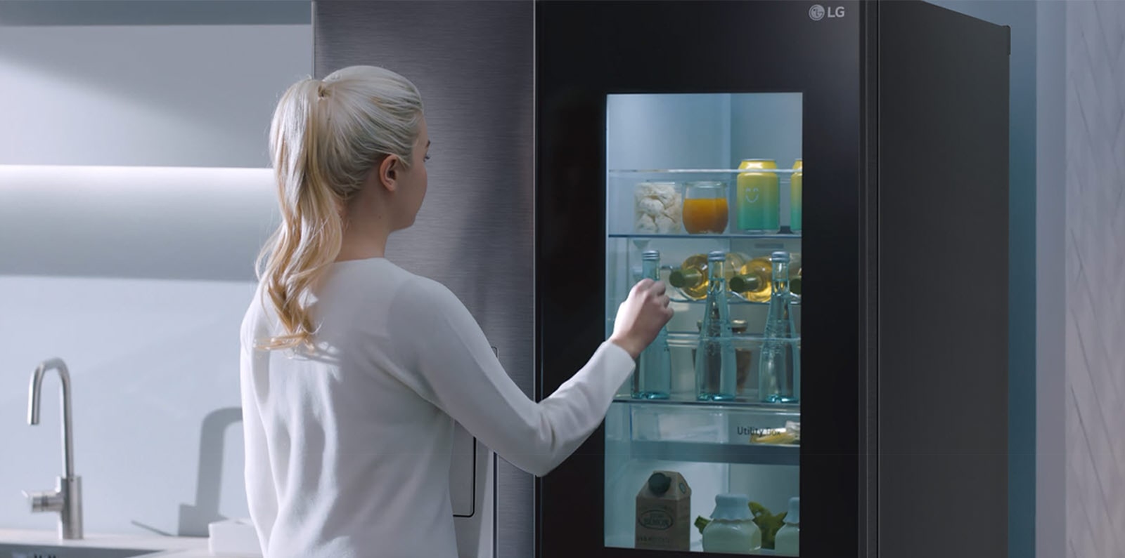 A video shows a woman approach her InstaView refrigerator and knock twice. The interior lights up and she can see the contents of her fridge without opening the door.
