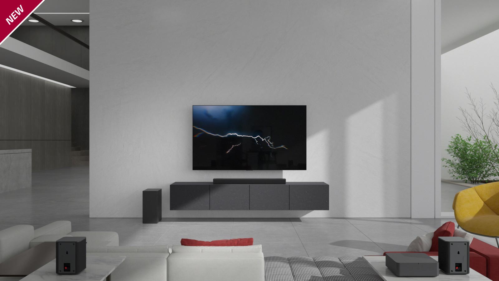 Lydplanken er plassert på et grått skap med en TV hengt på veggen i stuen. En trådløs subwoofer er plassert på gulvet på venstre side og sollyset kommer inn fra høyre side av bildet. En hvit- og rødfarget lang sofa står vendt mot TV-en og lydplanken. NYTT merke vises oppe i venstre hjørne.