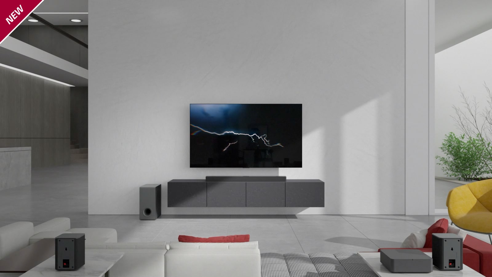 Lydplanken er plassert på et grått skap med en TV hengt på veggen i stuen. En trådløs subwoofer er plassert på gulvet på venstre side og sollyset kommer inn fra høyre side av bildet. En hvit- og rødfarget lang sofa står vendt mot TV-en og lydplanken. NYTT merke vises oppe i venstre hjørne.