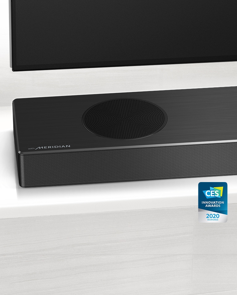 Nærbilde av LG Soundbars venstre side med Meridian-logoen vist på nedre venstre hjørne. Nedre venstre side av TVen er også synlig. 