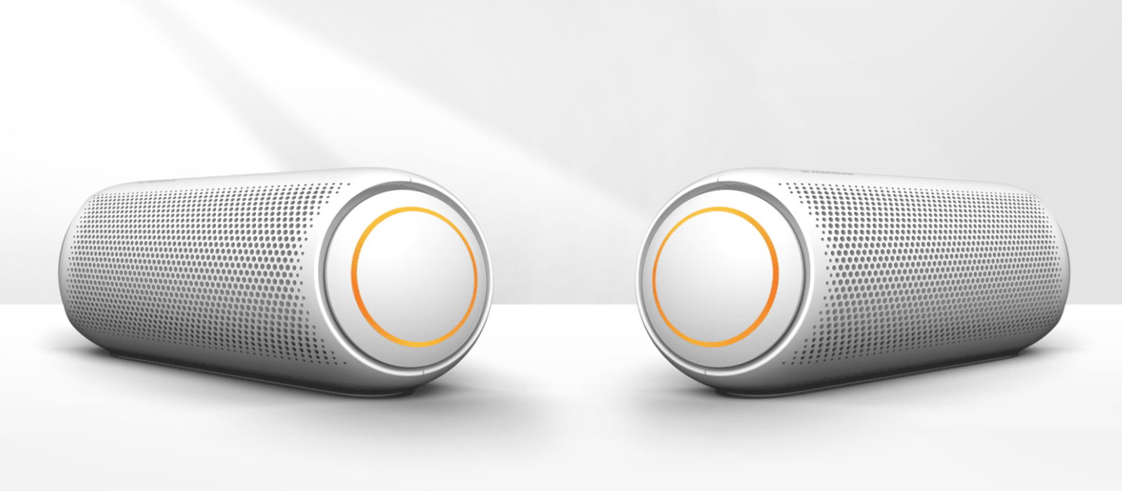 To XBOOM Go-er er vendt mot hverandre, mot en hvit bakgrunn. De har begge oransje lys. 