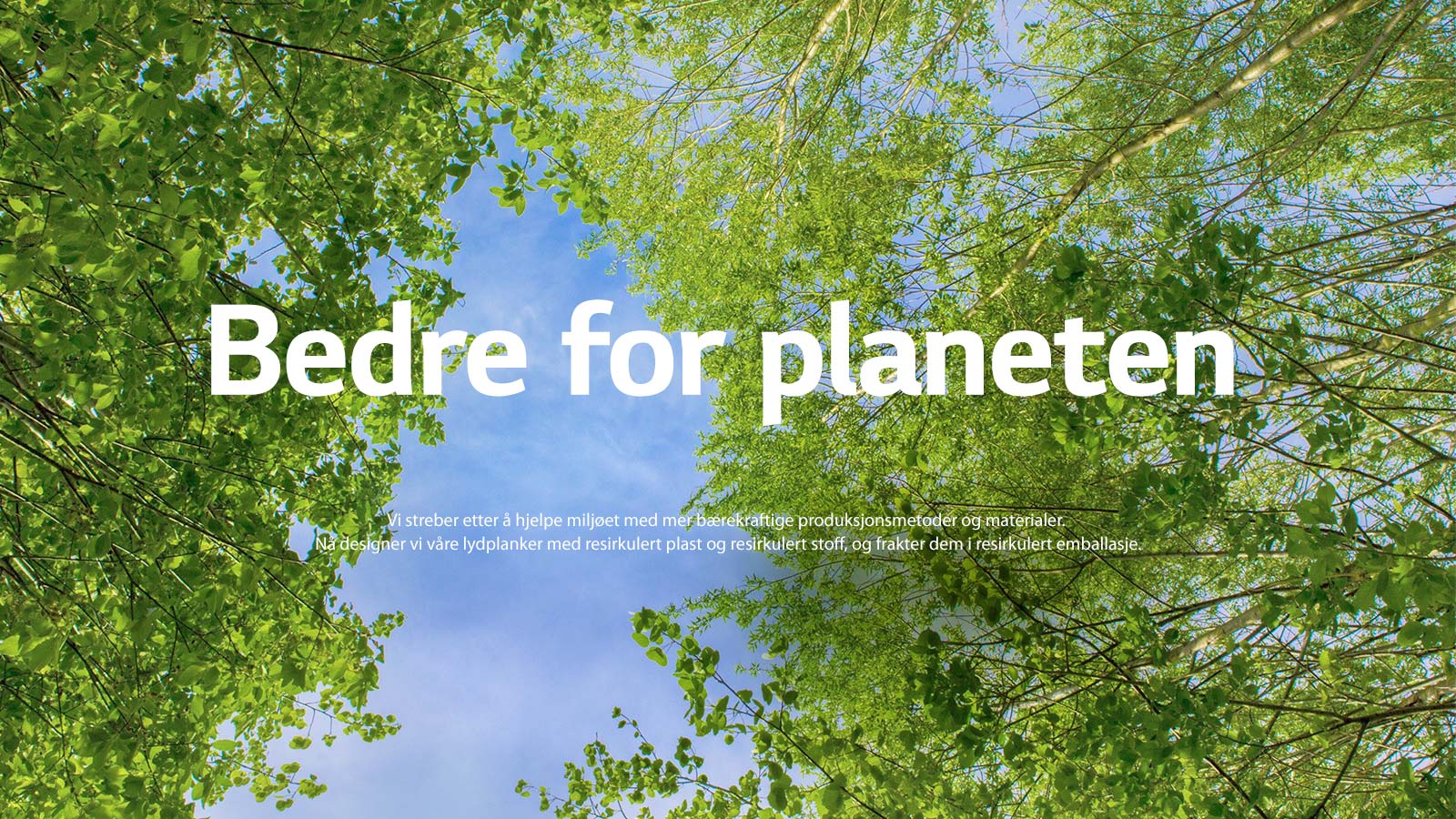 Et grønt bilde fullt av kraftige løvtrær og mellom trærne vises en sky