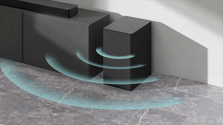 En lydplanke er plassert på skapet. Ved siden av en trådløs subwoofer plassert på gulvet. Blå lydgrafikk kommer ut fra subwooferen.