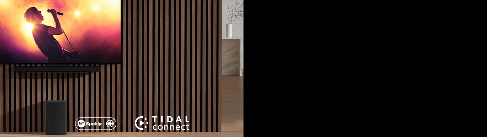 LG OLED C er plassert på veggen, under LG Sound Bar SC9S er plassert gjennom en eksklusiv brakett. Subwooferen er plassert under. TV-en viser en konsertscene.