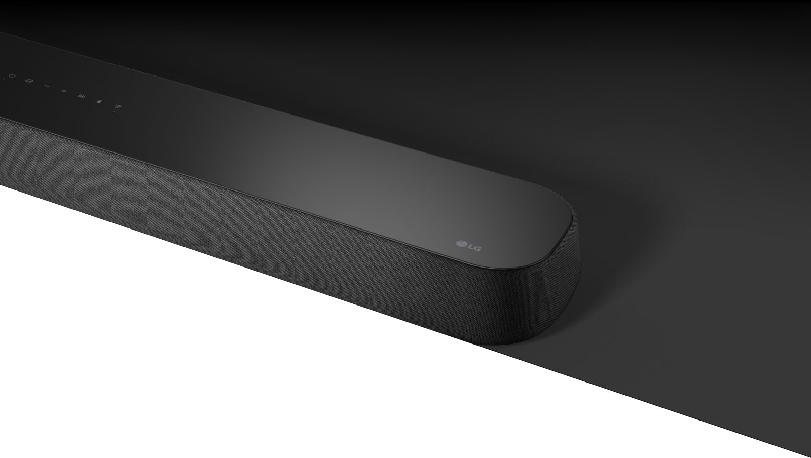 LG Sound Bar SE6S med diagonal visning er plassert på et svart område, og det er et hvitt område under for designformål.