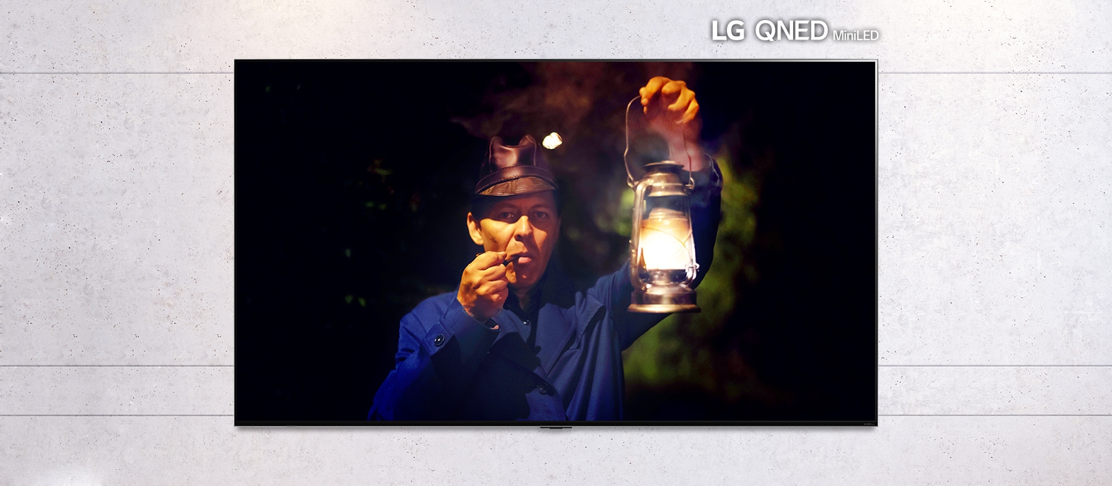 Rullbart bilde av en veggmontert TV som viser et mørk bilde av en mann som holder en lampe. Bildet veksler mellom en vanlig TV og en stor LG QNED MiniLED TV-skjerm.