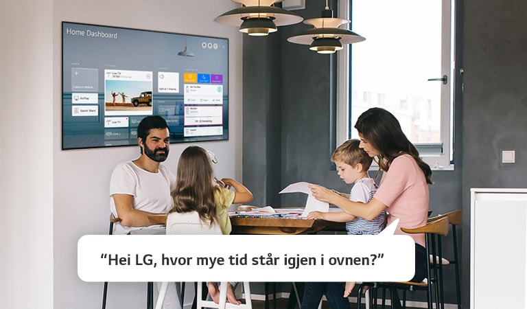 En familie sitter ved et bord hvor moren spør TV-en om hvor mye tid som står igjen for ovnen