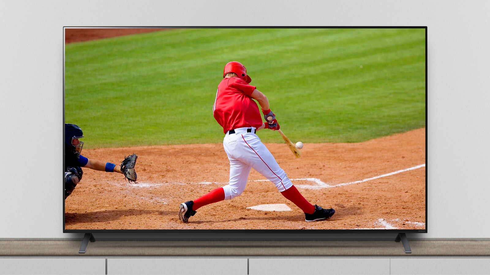 TV-en står på stativet og skjermen viser en baseballkamp.