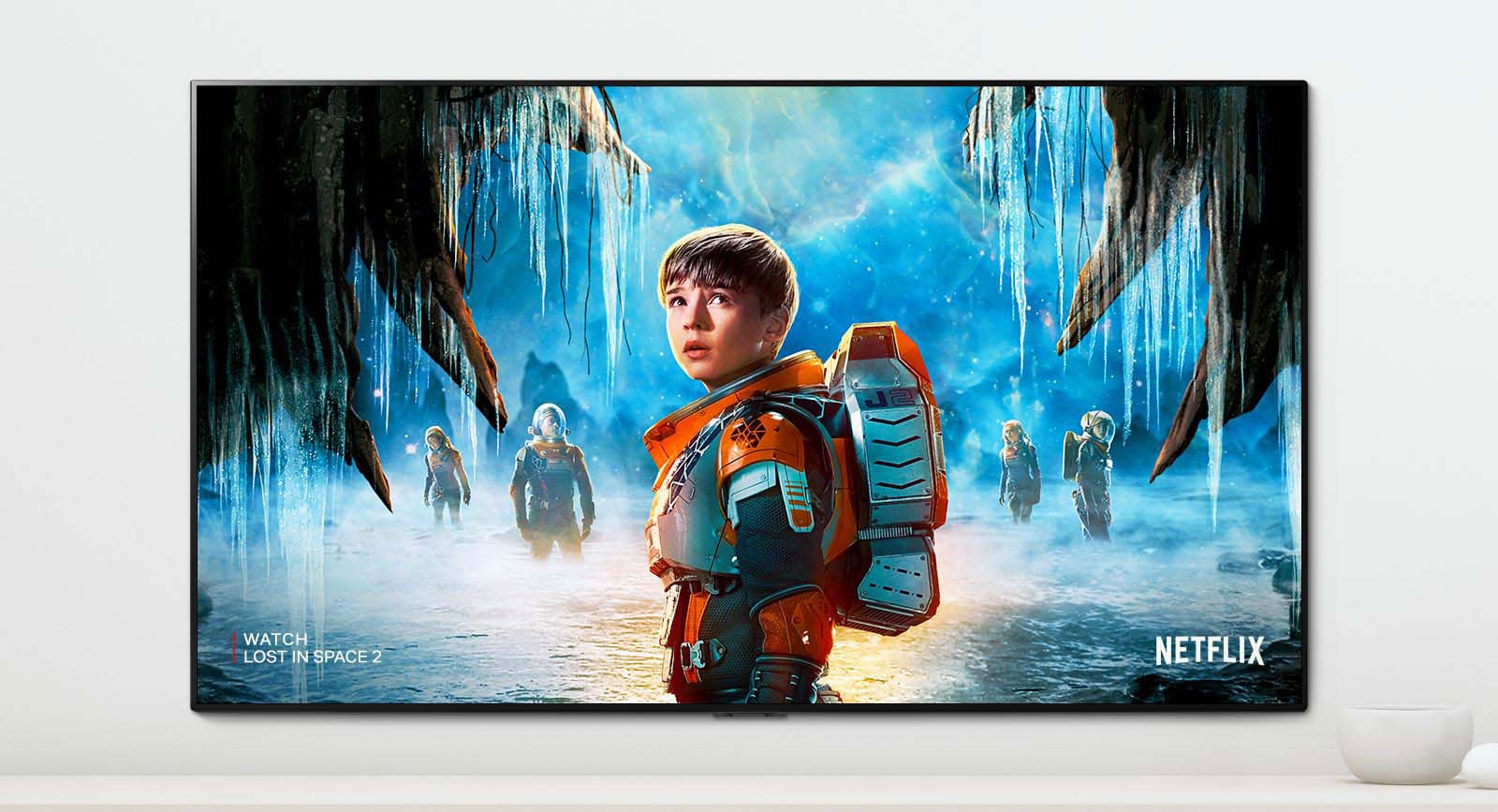 En scene av Lost in Space 2-serien som viser hovedpersoner med et intenst blikk på en TV-skjerm