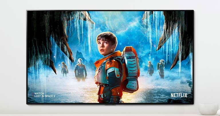 En scene av Lost in Space 2-serien som viser hovedpersoner med et intenst blikk på en TV-skjerm