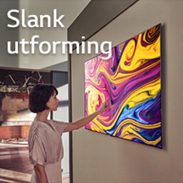 En kvinne ser på en TV som henger på veggen og viser kunst.
