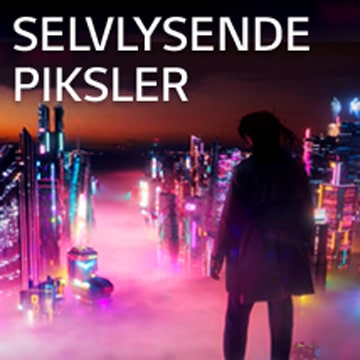 En kvinne ser ned på byen med fargerike neonskilt om natten.