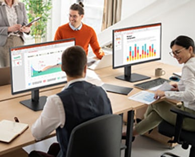 Ansatte som sitter ved kontorpulter og har en samtale.	