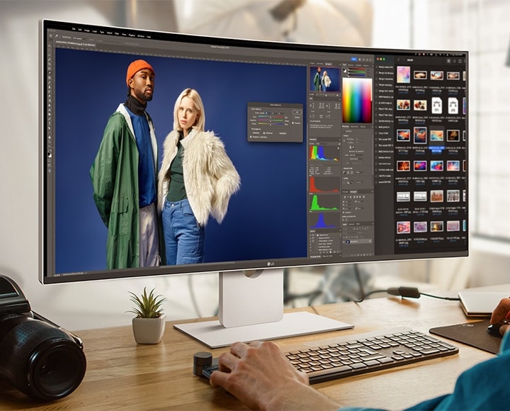 En mann jobber med et designprogram på UltraFine-skjermen. Et kamera er plassert ved siden av skjermen.	
