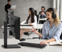 En kvinne med headset snakker med en kunde i et kundesenter.
