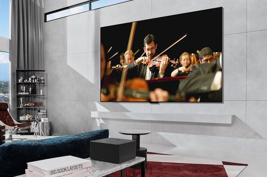 LG Verdens første ekte trådløse TV 77 tommer LG OLED evo AI M4 med 4K 144 Hz video- og lydoverføring , LG OLED evo M4, jonka näytöllä on orkesteri, on asennettu seinälle. Sen edessä on Zero Connect Box, jonka alle muut laitteet on asetettu siististi paikalleen., OLED77M49LA, thumbnail 16