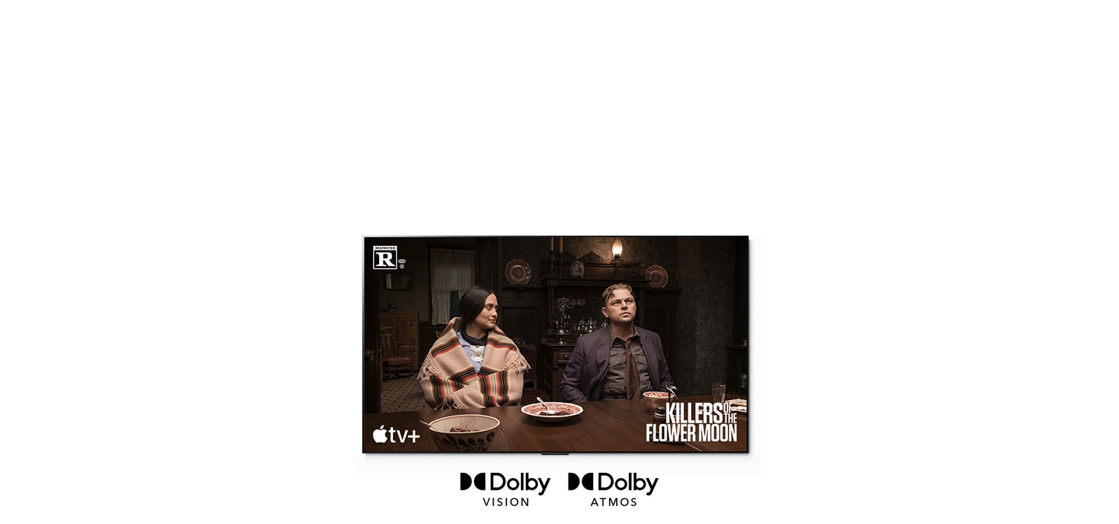 Et bilde av en mann og en kvinne som sitter sammen ved bordet, som er en scene fra filmen «Killers of the Flower Moon».