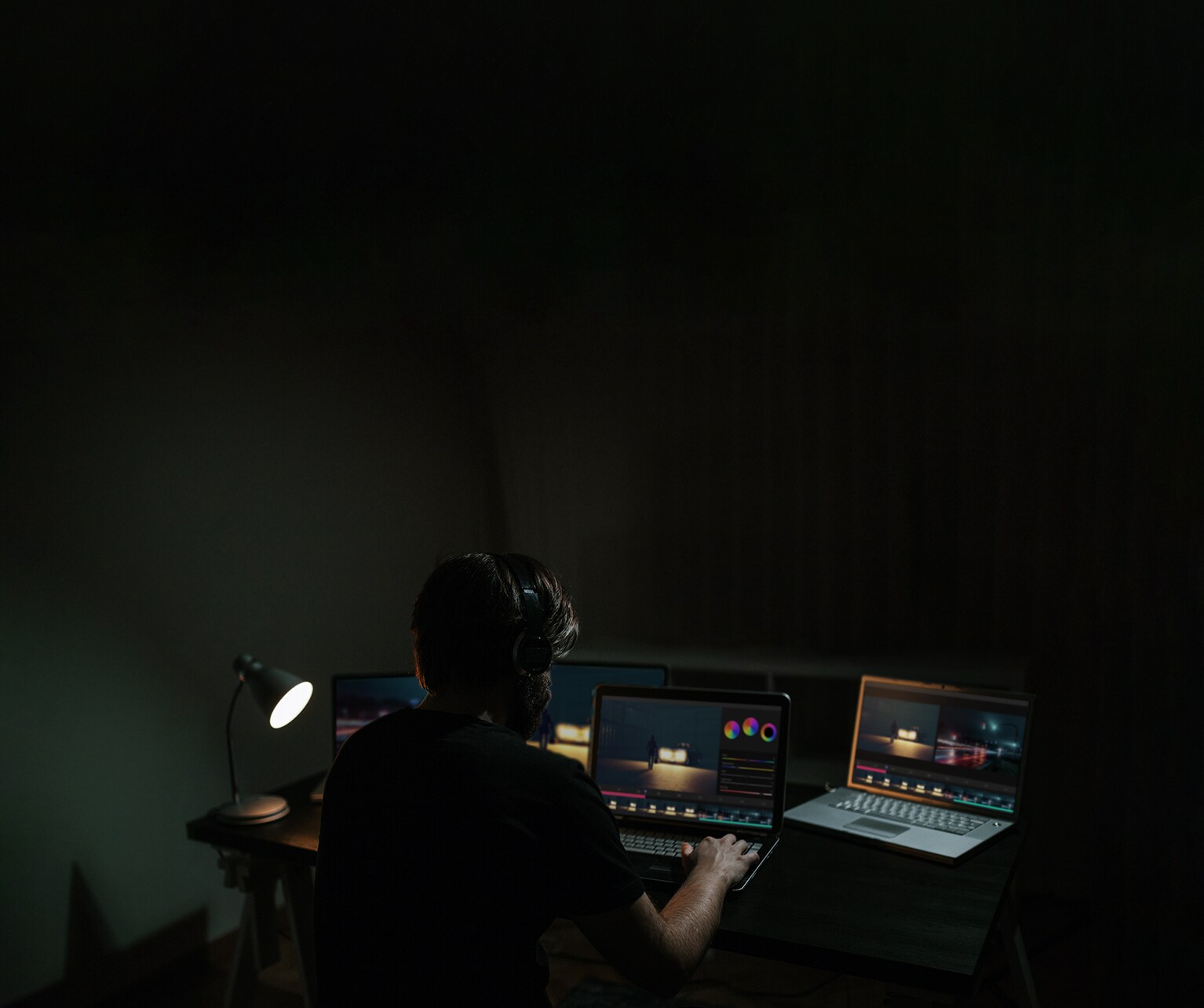 En mann redigerer en film samtidig som han ser på programvare på en dataskjerm