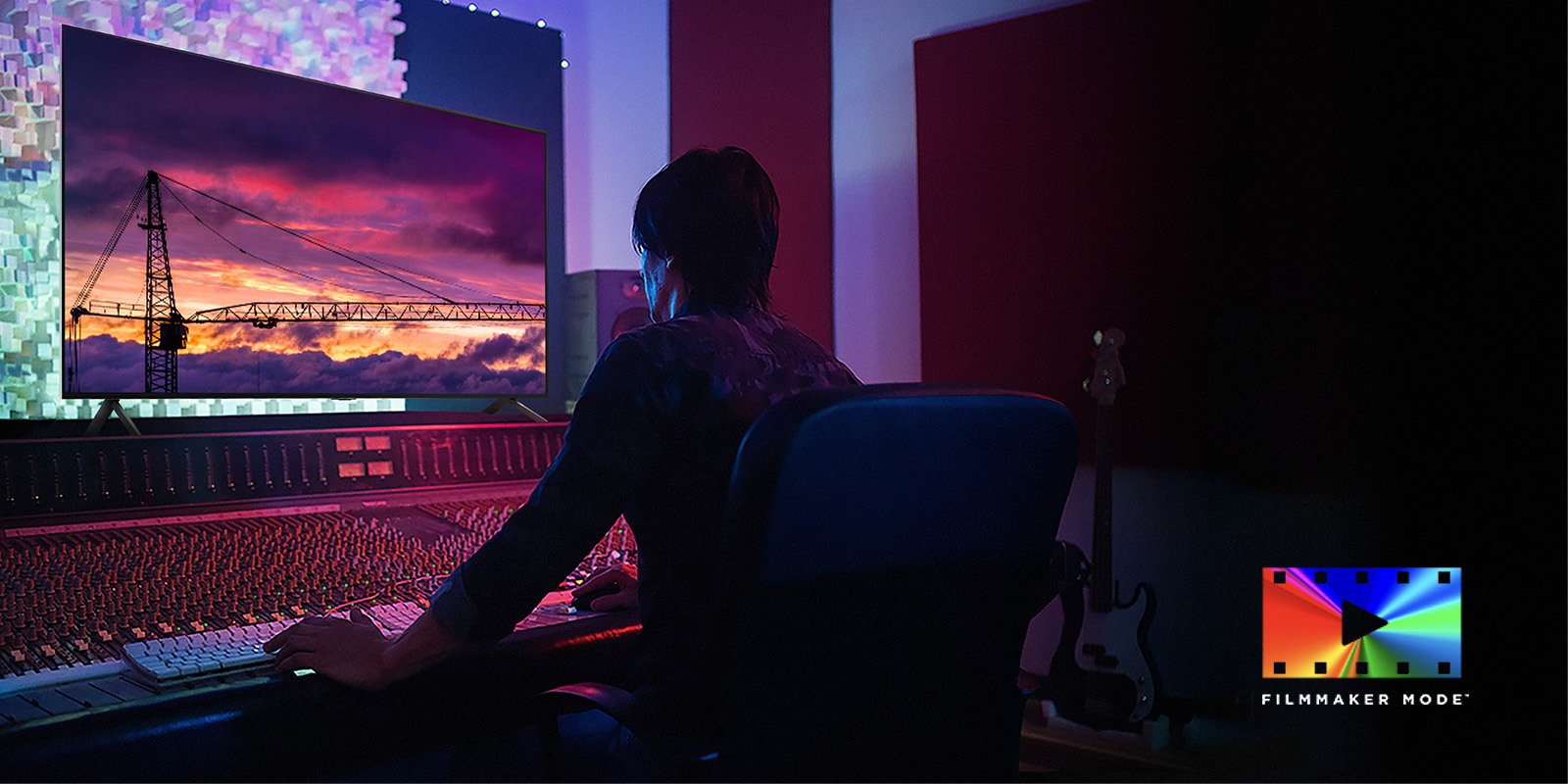 A man in a dark editing studio looking at an LG TV displaying the sunset. On the right bottom of the image is a FILMMAKER Mode logo.
