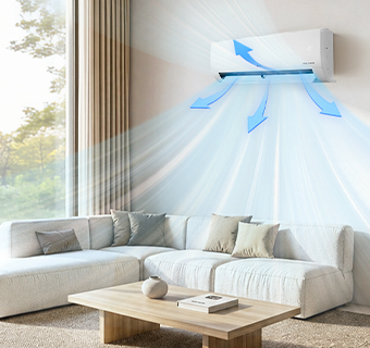 A wall-mounted air conditioner blowing cool air into a modern, minimalist living room with a beige sofa.