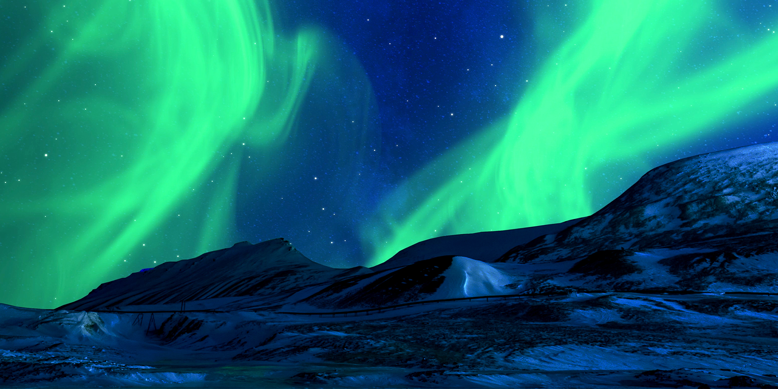 Winter landscape of snowy mountains with starry night sky and green polar lights in the background.
