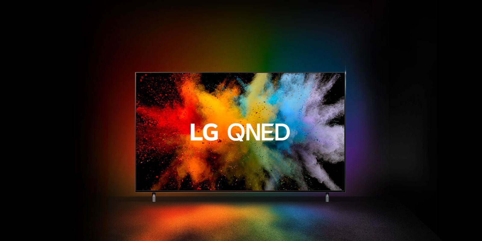 Telewizor LG QNED w ciemnym pomieszczeniu. Farbowane proszki tworzą eksplozję tęczowych kolorów na telewizorze.