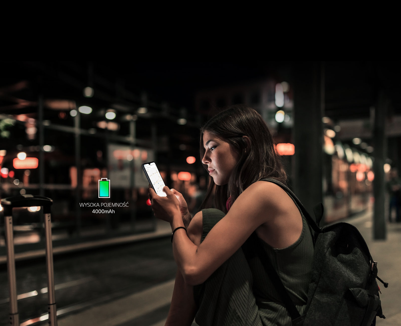 Kobieta przeglądająca internet na smartfonie późno w nocy na stacji metra z dużym  zapasem  energii w baterii