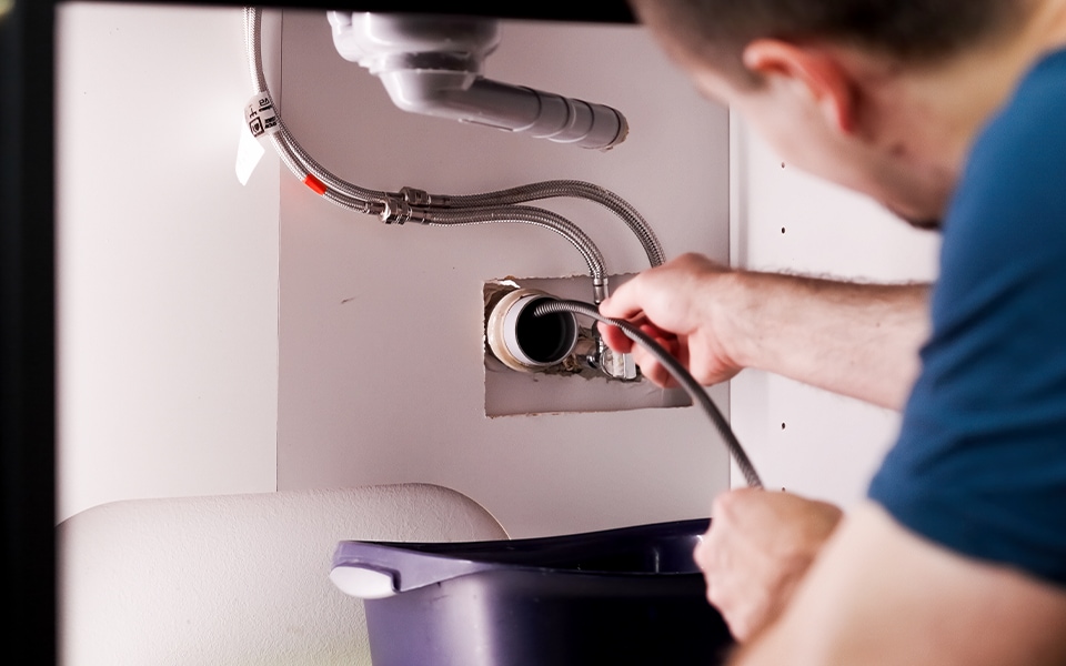 A technician checking the hose on an LG washing machine.