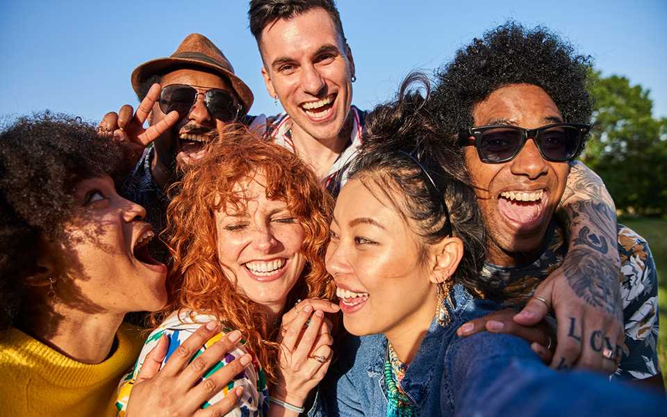 A group of young people smiling whilst taking a photo on a LG WING