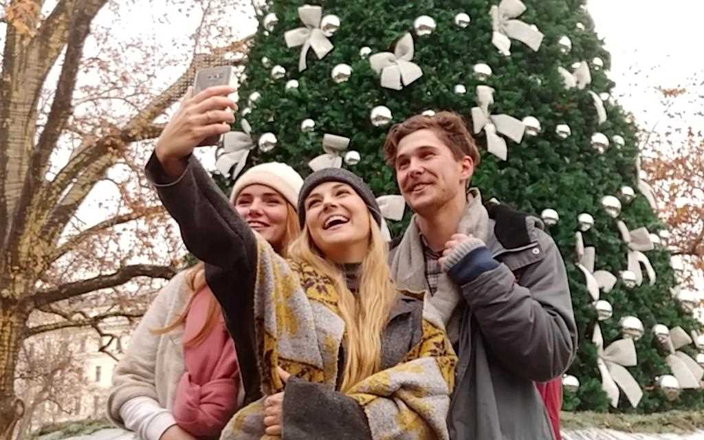 A group of young people taking a selfie with the LG V30 smartphone at the Christmas markets.