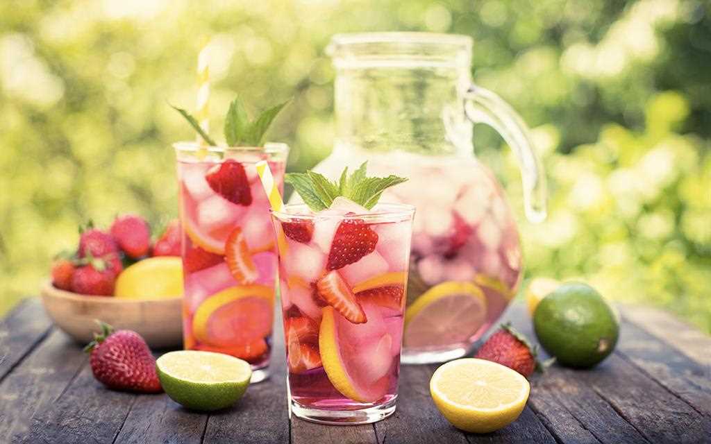 A front view of fruity summer punches with strawberry, limes, and lemons.