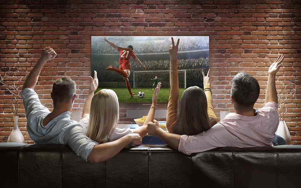 A group of friends watching a sport match from lg super uhd 4k tv.