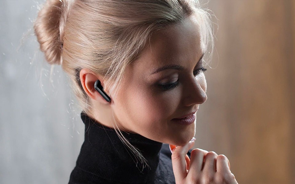 A woman wearing LG Tone Free wireless earbuds