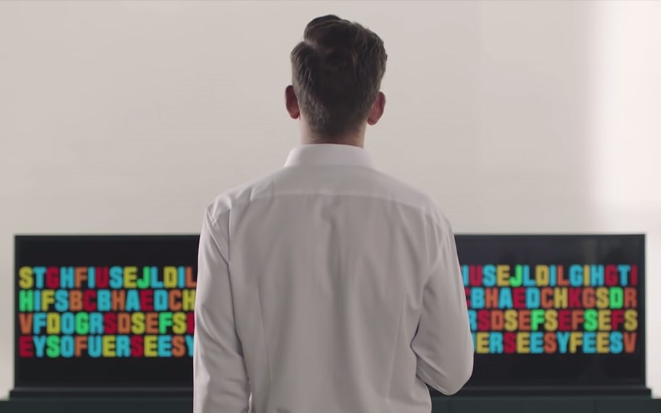 A man standing in front of multiple LG OLED TVs.