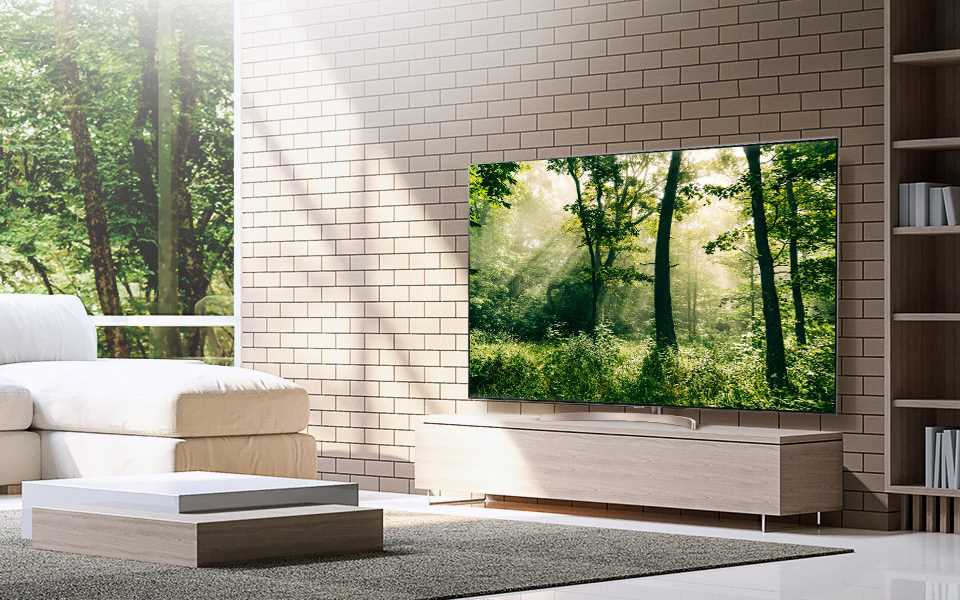 The LG Super UHD Nanocell TV, located in a living room, displaying a vibrant image of a forest.