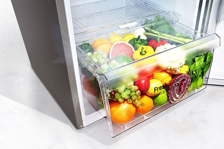 Imagine cu fructe și legume proaspete în zona de prospețime a frigiderului.