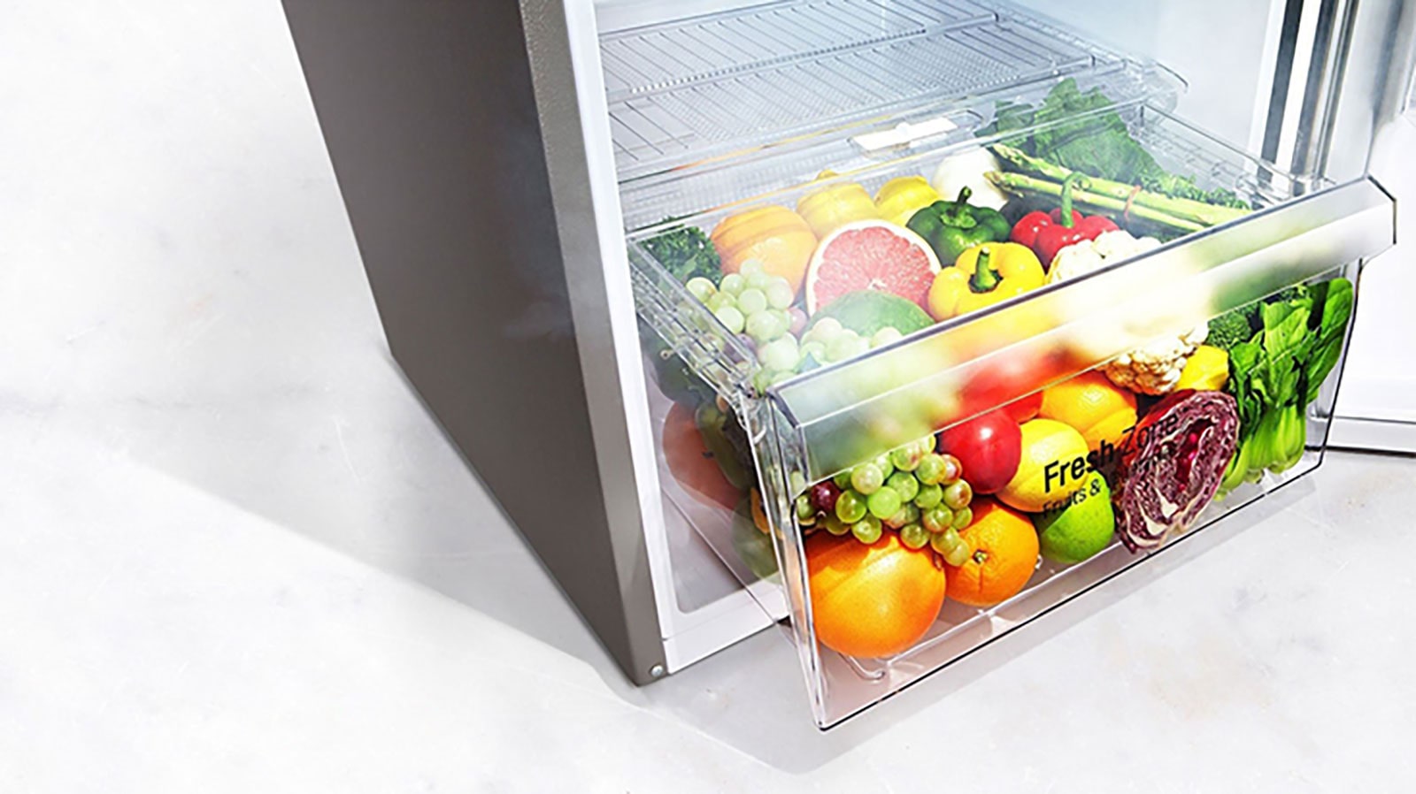 Imagine cu fructe și legume proaspete în zona de prospețime a frigiderului.