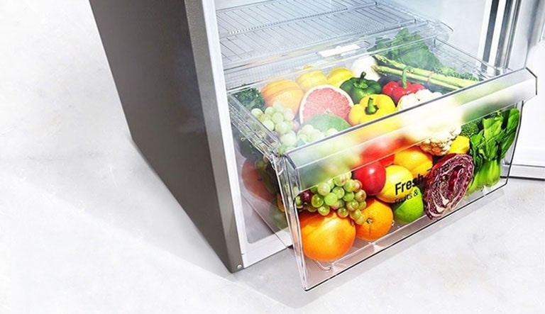 Imagine cu fructe și legume proaspete în zona de prospețime a frigiderului.