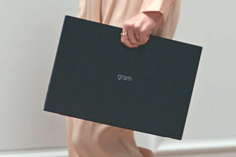 O femeie ține laptopul LG gram într-o mână