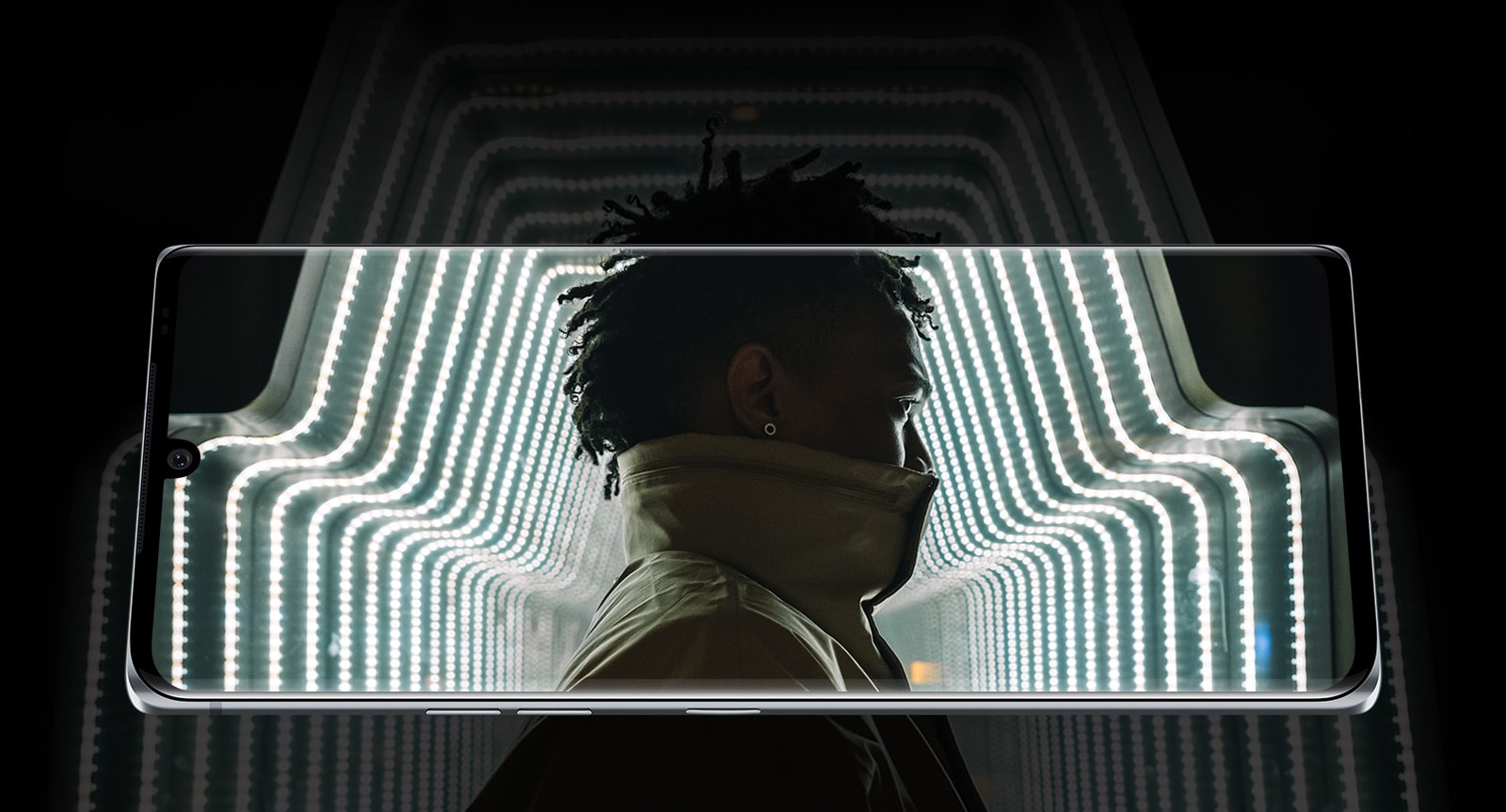 Un bărbat într-un tunel de lumini, pe un fundal întunecat.