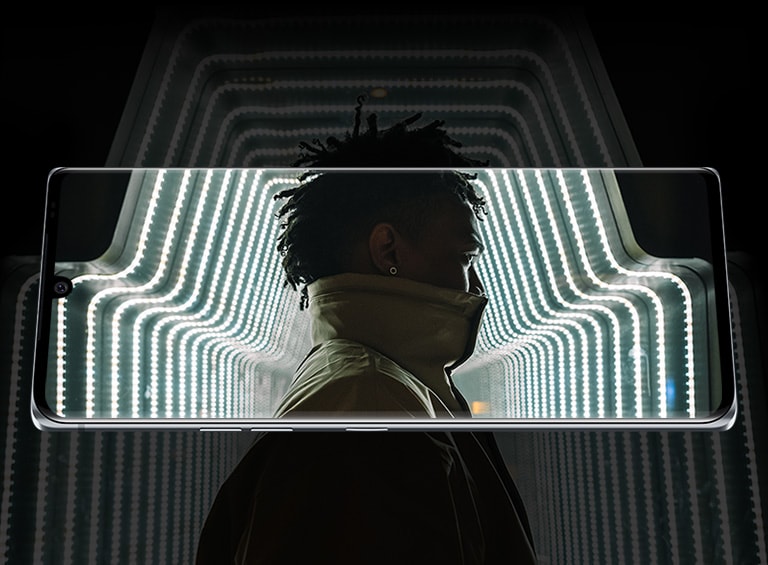 Un bărbat într-un tunel de lumini, pe un fundal întunecat.