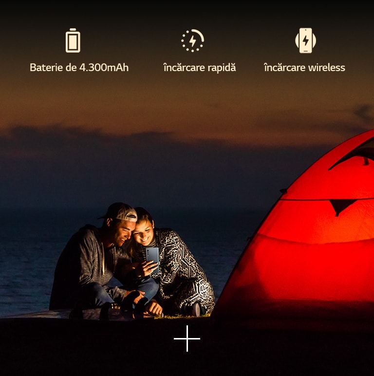 Un cuplu în fața unui cort, pe timp de noapte